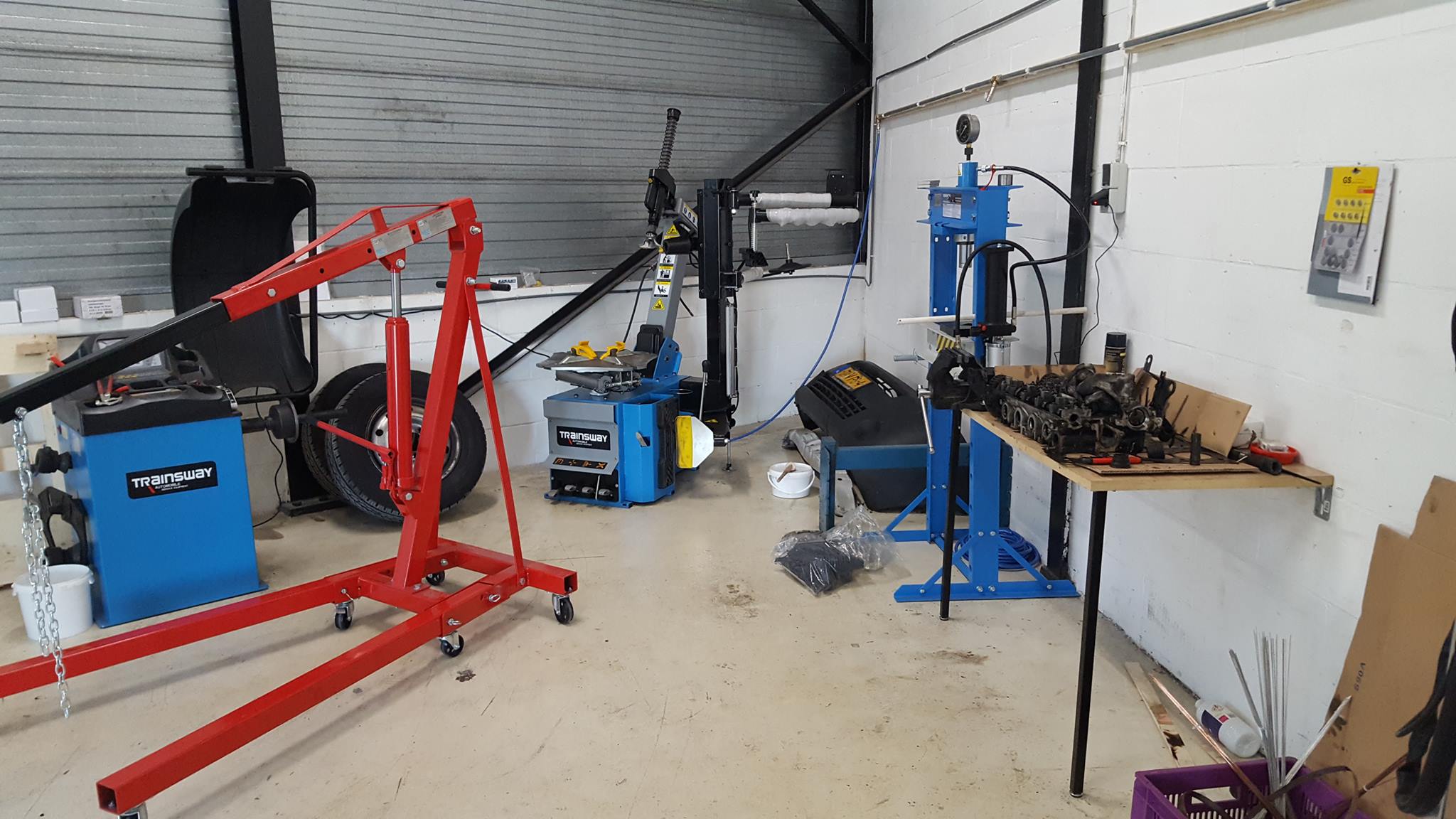 Bandenwisselaar, balanceermachine, motorkraan en pers in de werkplaats van Garagebedrijf Karol