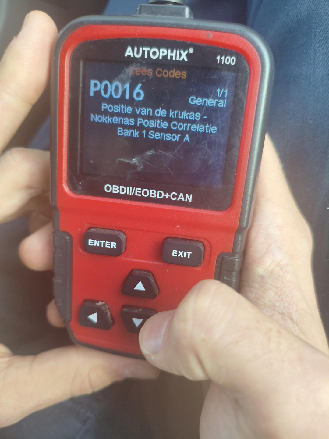 Uitleesapparaat in twee handen met de foutcode P0016 op het scherm